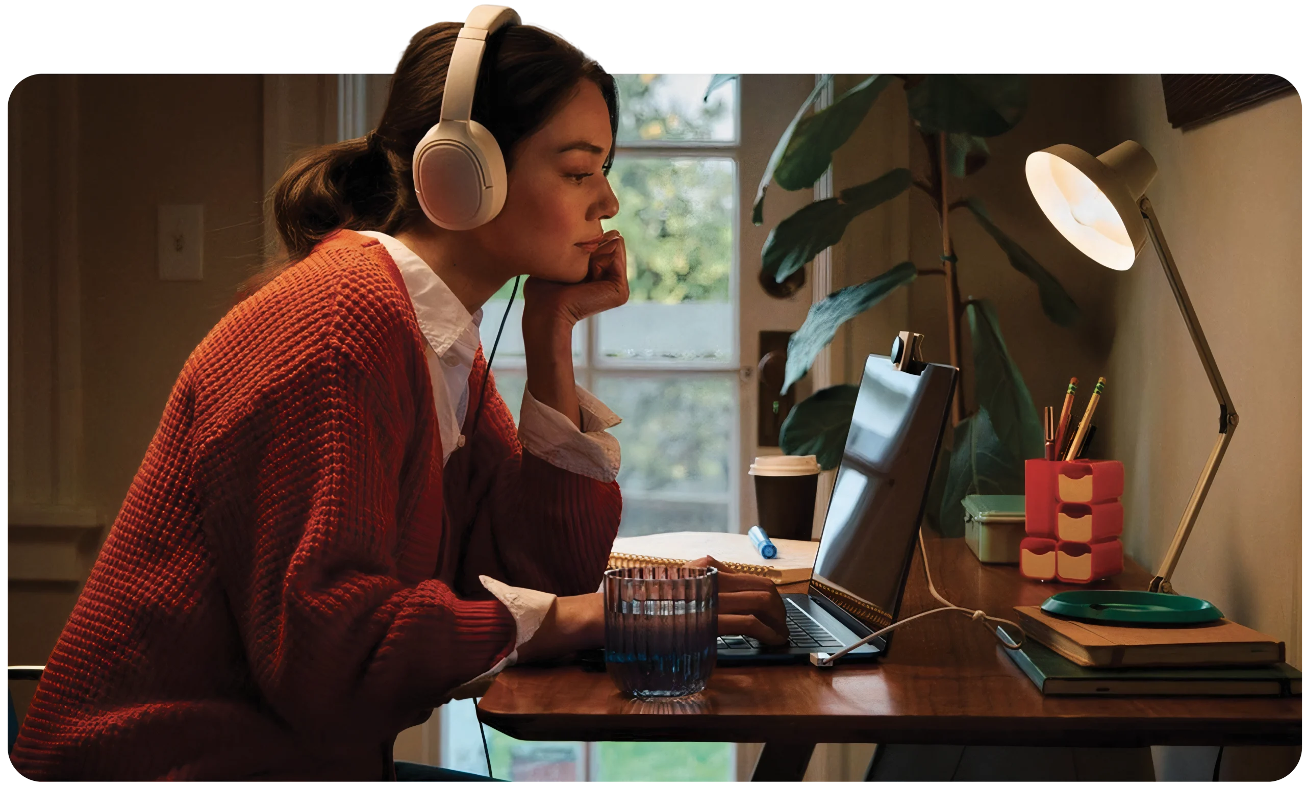 Jeune fille de profil très concentrée travaillant sur son ordinateur à son bureau